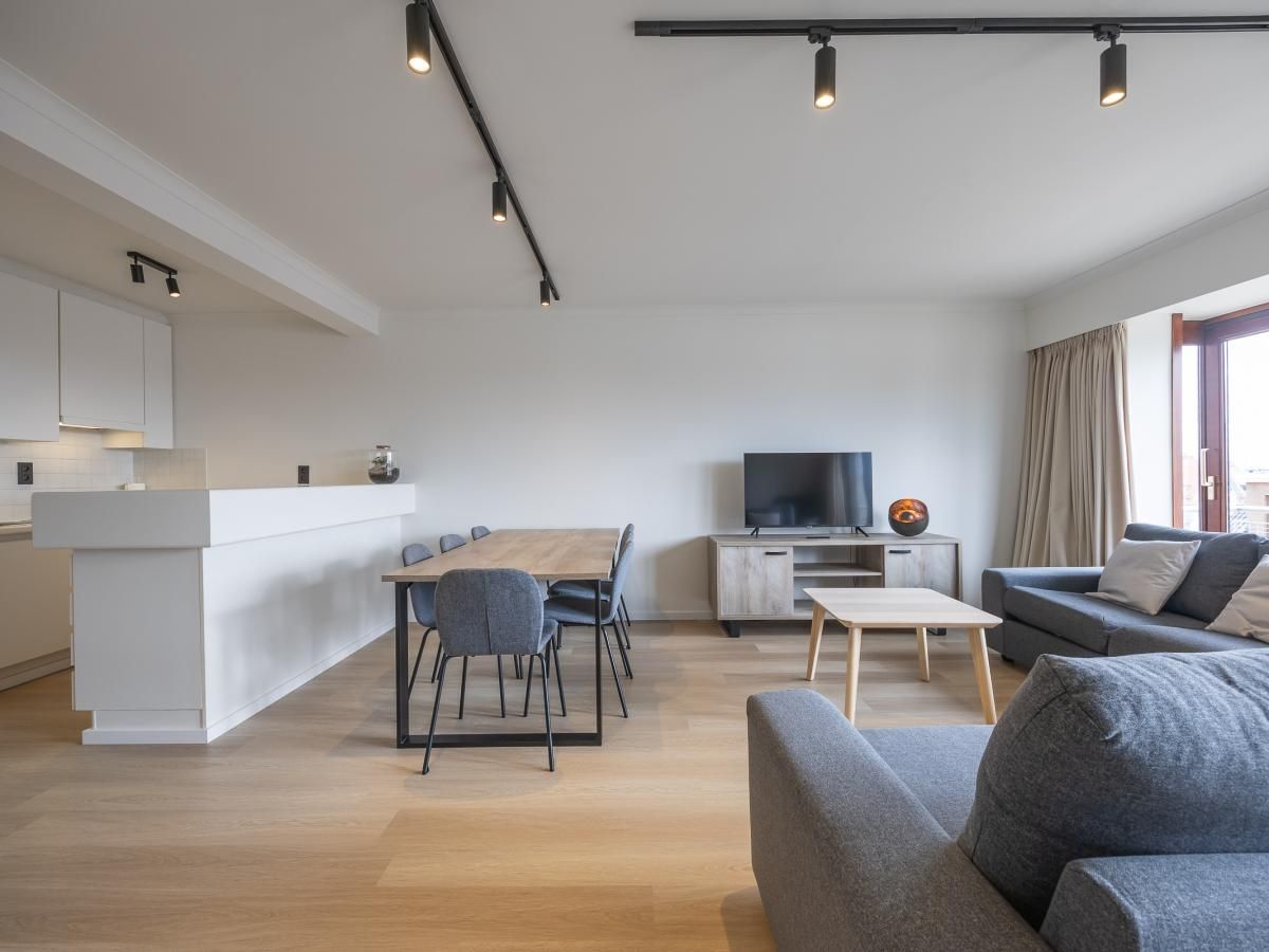Modernes Wohnzimmer im Ferienhaus Harmony - 0301, Middelkerke, Westflandern, mit gemuetlicher Sitzecke und Essbereich.