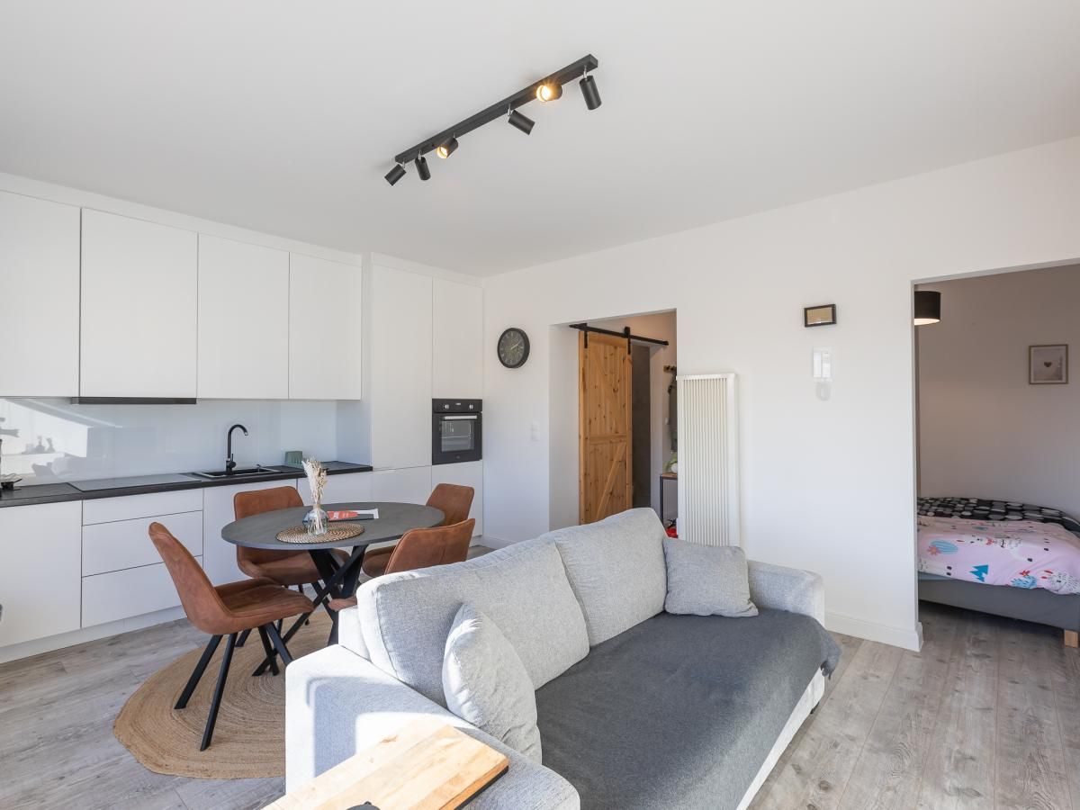 Modernes Wohnzimmer und Kueche im Ferienhaus Hawaii - 0003, Middelkerke, Belgien, mit komfortabler Einrichtung und viel Tageslicht.