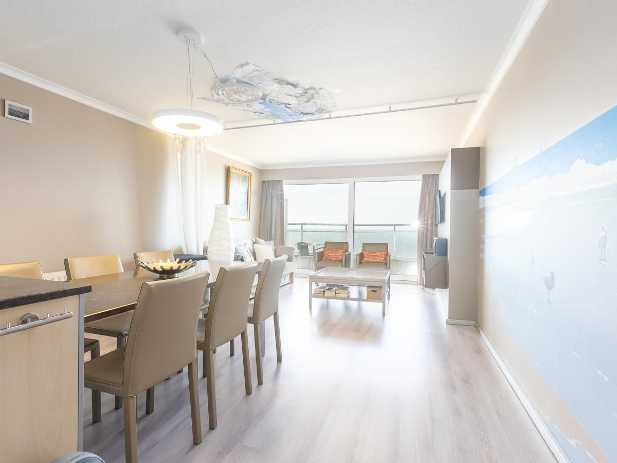 Helles Wohnzimmer des Ferienhauses Long Beach 1 - 0904 in Middelkerke, Westflandern, mit moderner Einrichtung und Blick auf die Terrasse.