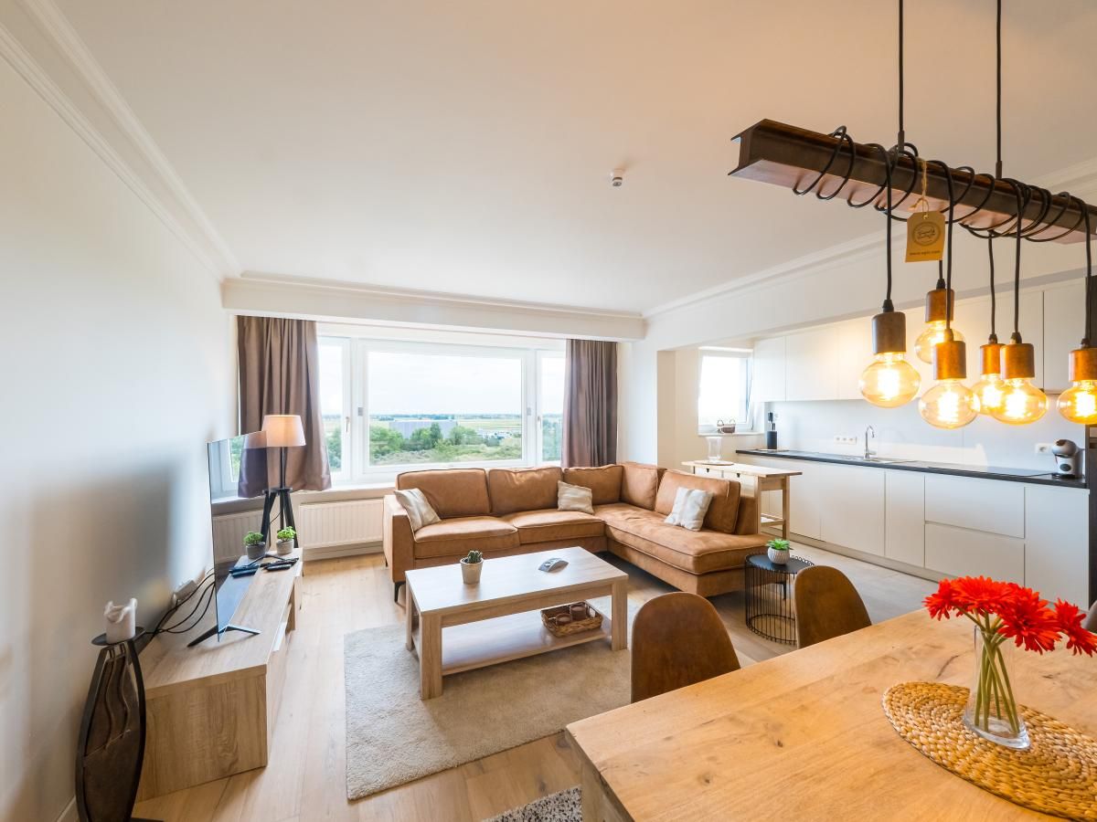 Gemuetliches Wohnzimmer im Ferienhaus Majestic - 0505, Middelkerke, Westflandern mit Blick auf die Natur durch grosse Fenster.