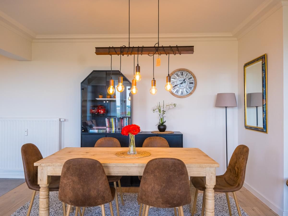 Stilvolle Essecke im Ferienhaus Majestic - 0505, Middelkerke, Westflandern mit Holztisch und moderner Beleuchtung.