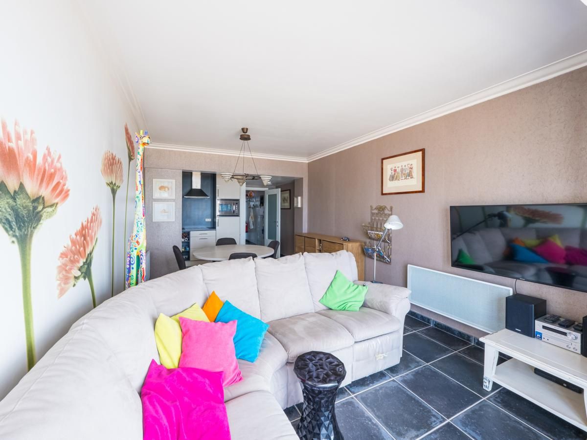 Gemuetliches Wohnzimmer im Ferienhaus Stella - 0701 in Middelkerke, Westflandern, mit bunten Kissen und modernen Moebeln.