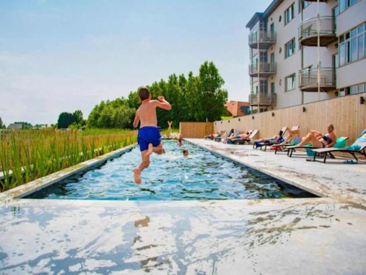 Genieten van het zwembad bij vakantiehuis West Bay in Westende, West-Vlaanderen, Belgie, met uitzicht op de natuur en ontspannende sfeer.