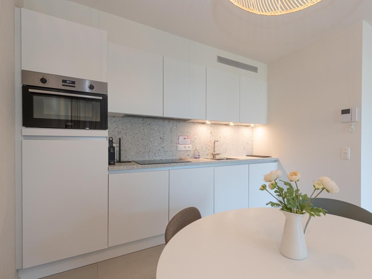 Moderne keuken in West Bay vakantiehuis in Westende, West-Vlaanderen, Belgie met stijlvolle inrichting en comfortabele eetruimte.