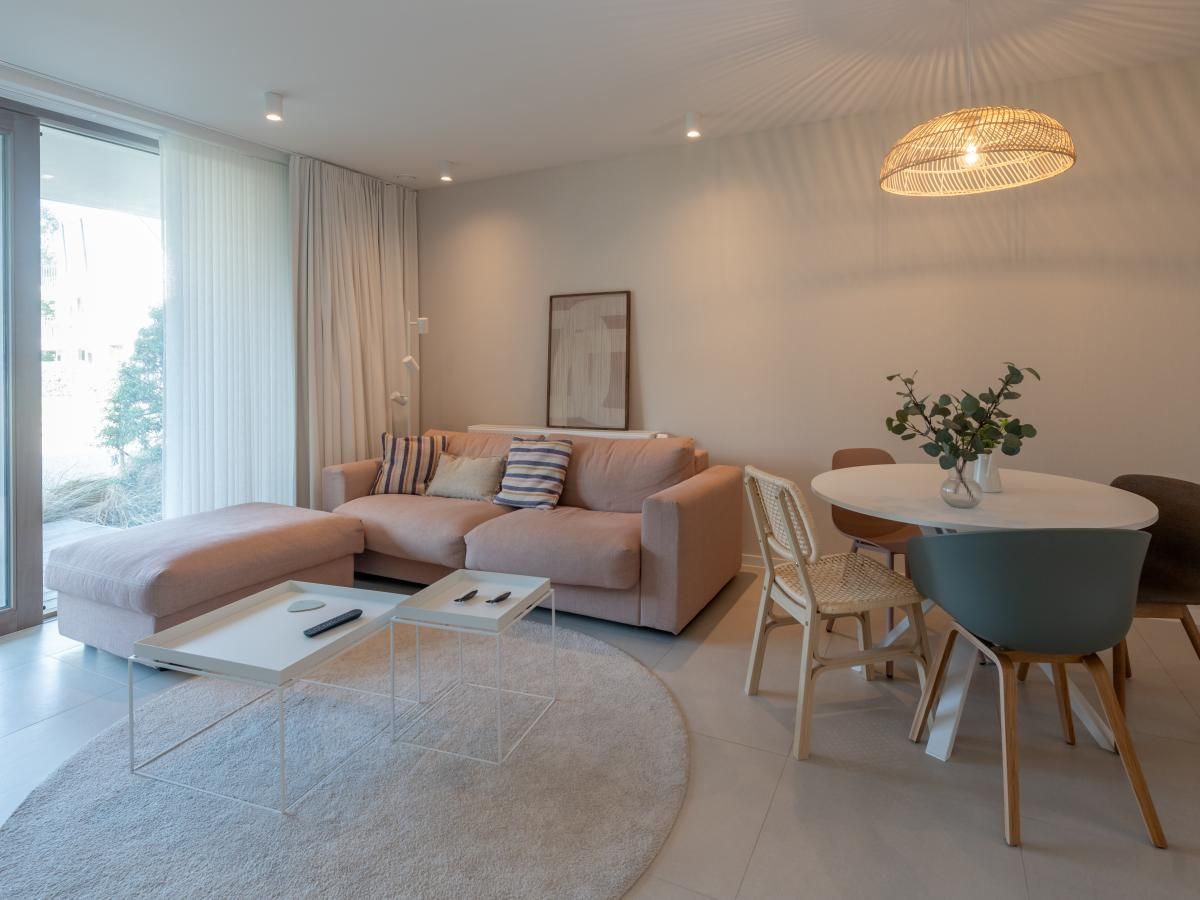 Gezellige woonkamer in vakantiehuis West Bay, Westende, West-Vlaanderen met moderne inrichting en comfortabele zithoek.
