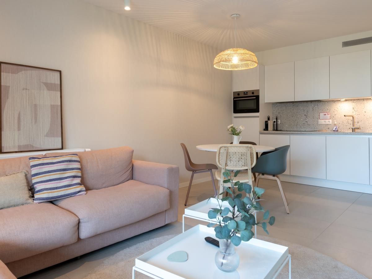 Gezellige woonkamer in vakantiehuis West Bay, Westende, West-Vlaanderen met moderne keuken en comfortabele zithoek.