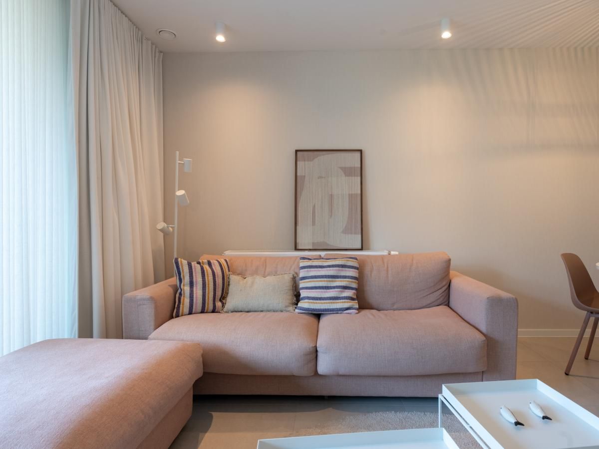 Gezellige woonkamer in vakantiehuis West Bay, Westende, West-Vlaanderen, met comfortabele sofa en stijlvolle inrichting voor een ontspannen verblijf.
