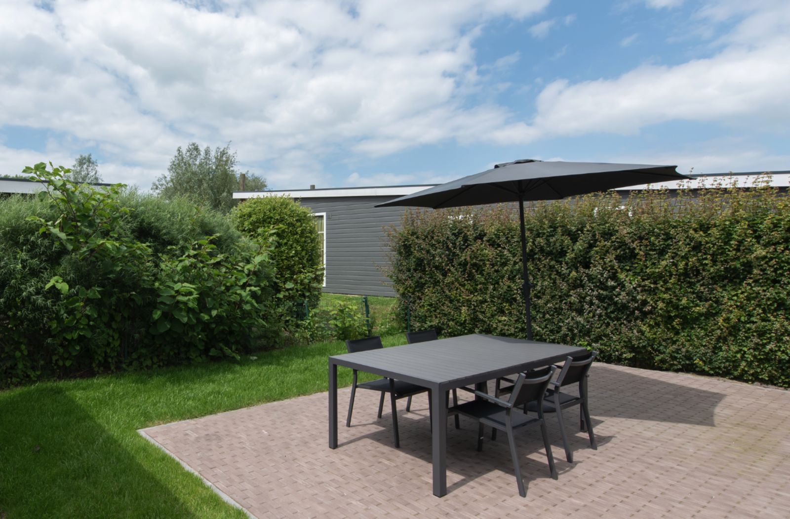 Geniessen Sie den Platz im Freien in der Access Lodge in Westende, Westflandern, Belgien, mit einer gemuetlichen Terrasse und einer gruenen Umgebung.
