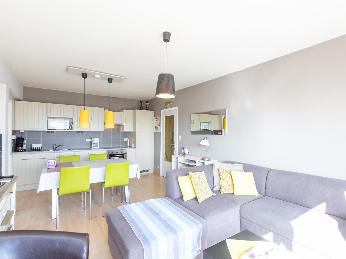 Lichte woonkamer van vakantiehuis Con Amore - 0403 in Westende, Belgie, met moderne open keuken en comfortabele zithoek.