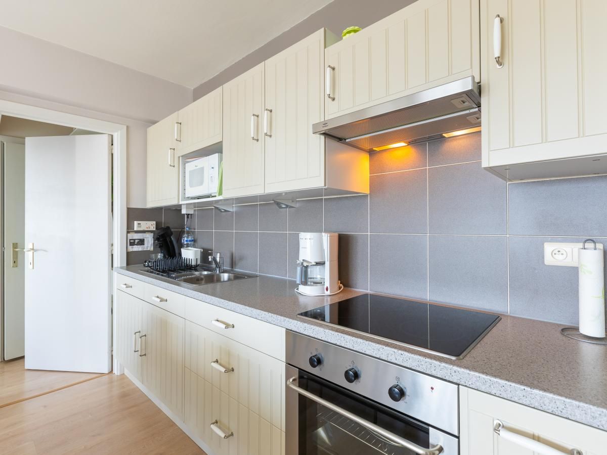 Moderne keuken in vakantiehuis Con Amore - 0403 in Westende, West-Vlaanderen, Belgie met strakke kastjes en apparatuur.