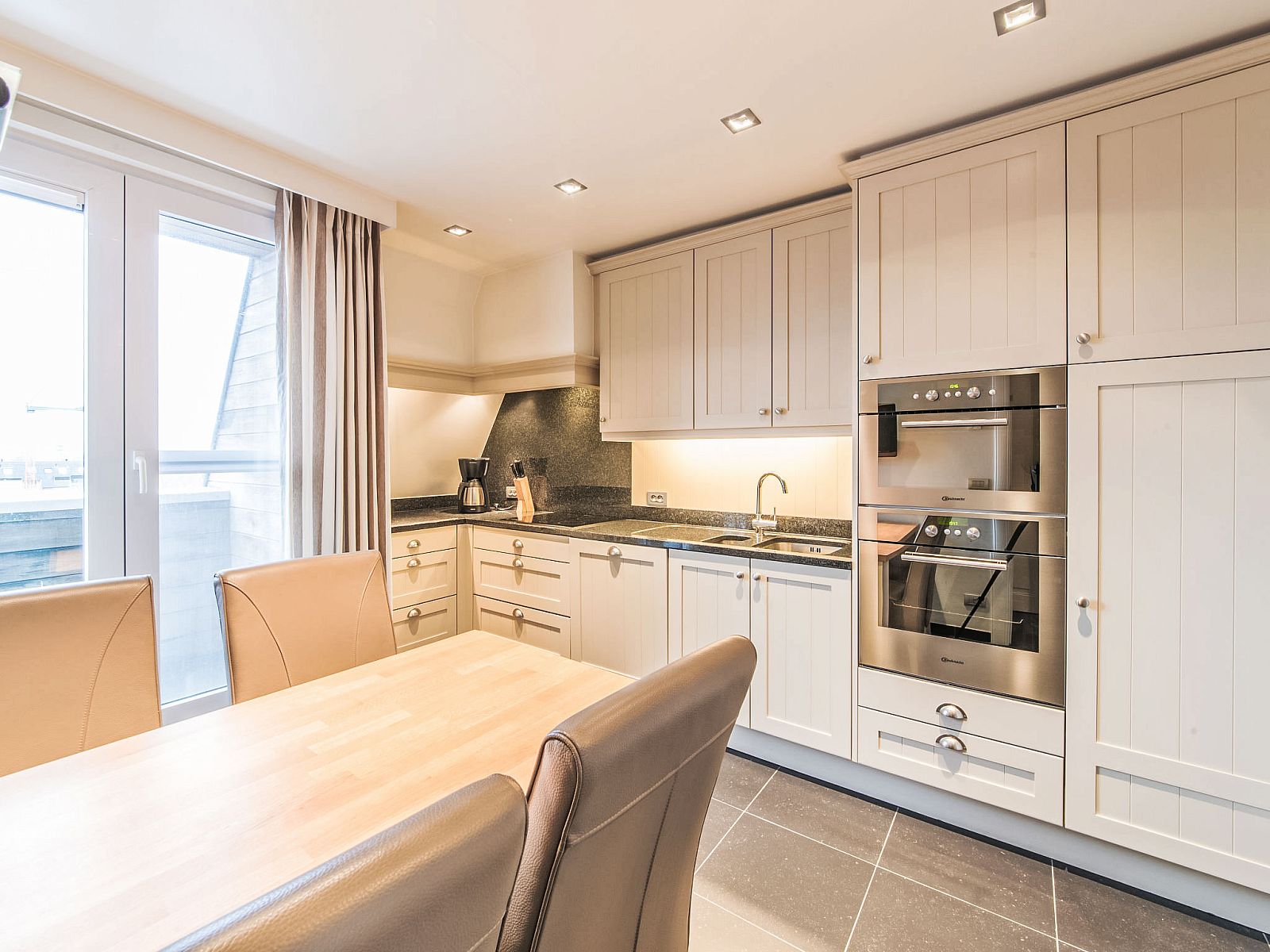 Moderne Kueche im Apartment Duplex, Bredene, Westflandern, mit stilvollem Dekor und viel natuerlichem Licht.