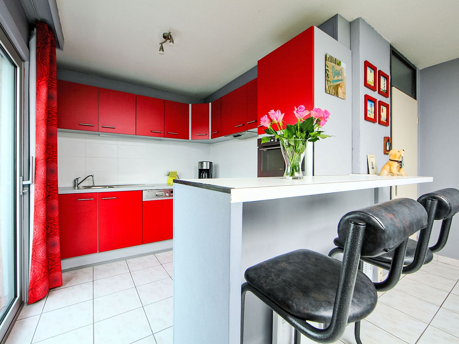 Stylish kitchen in Apartment Apt. 403, Bredene, West Flanders with modern red cabinets and a cozy bar area.
