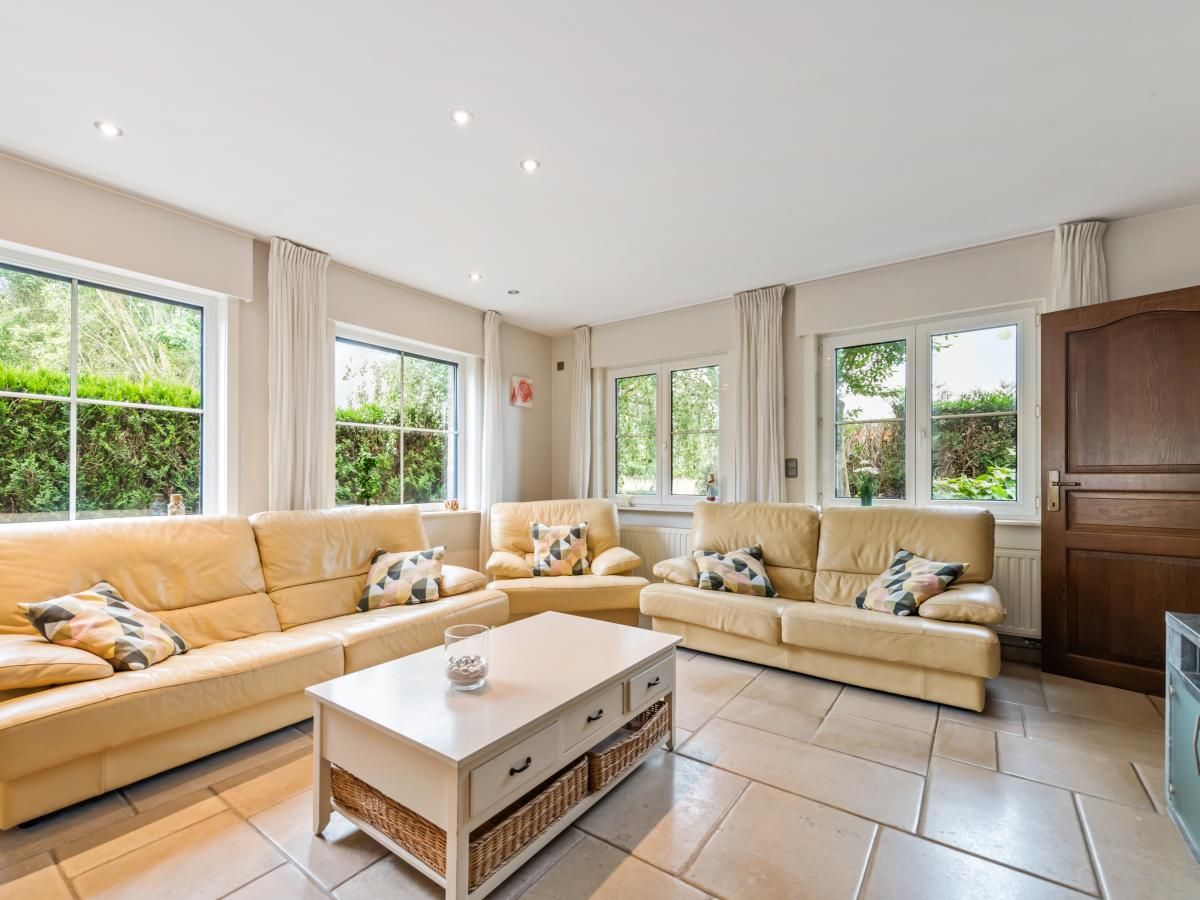 Gezellige woonkamer van vakantiehuis Frontzate in Diksmuide, West-Vlaanderen met comfortabele banken en veel natuurlijk licht.