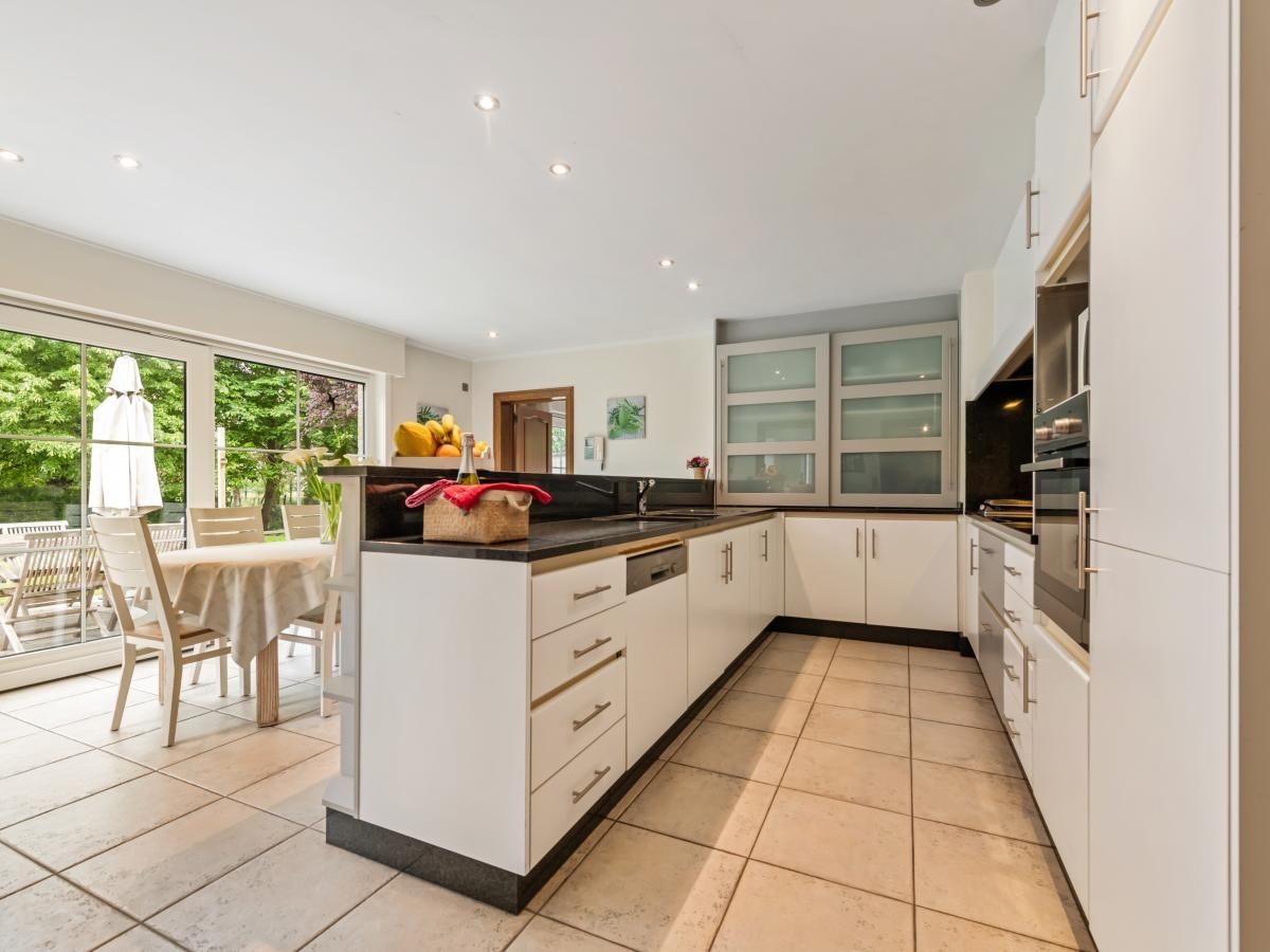 Gezellige eetkamer in vakantiehuis Frontzate te Diksmuide, West-Vlaanderen, met elegant gedekte tafel en uitzicht op de groene omgeving.