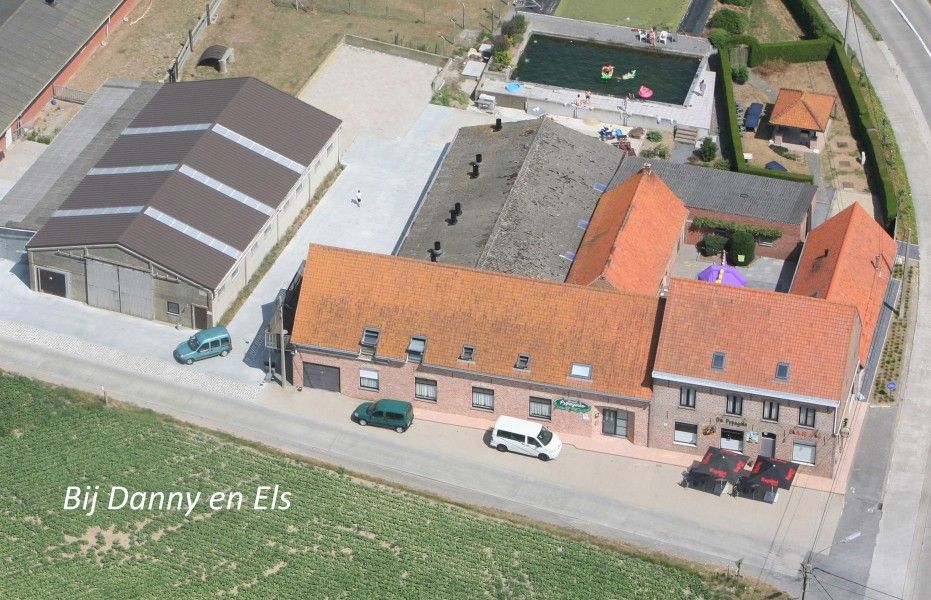 Luchtfoto van vakantiehuis de Pypegale in Lo-Reninge, West-Vlaanderen met zwembad en landelijke omgeving.