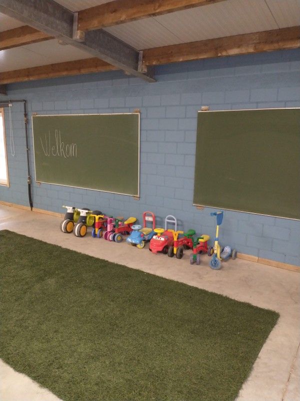 Speelruimte met kinderfietsen en krijtborden in vakantiehuis de Pypegale, Lo-Reninge.