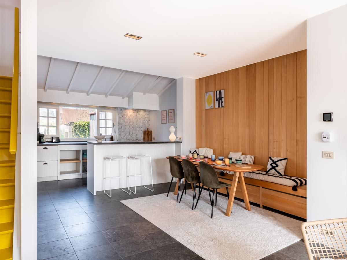 Stilvoller Innenbereich des Ferienhauses "Magique 31" in Oostduinkerke, Belgien, mit moderner Kueche und gemuetlichem Essbereich.