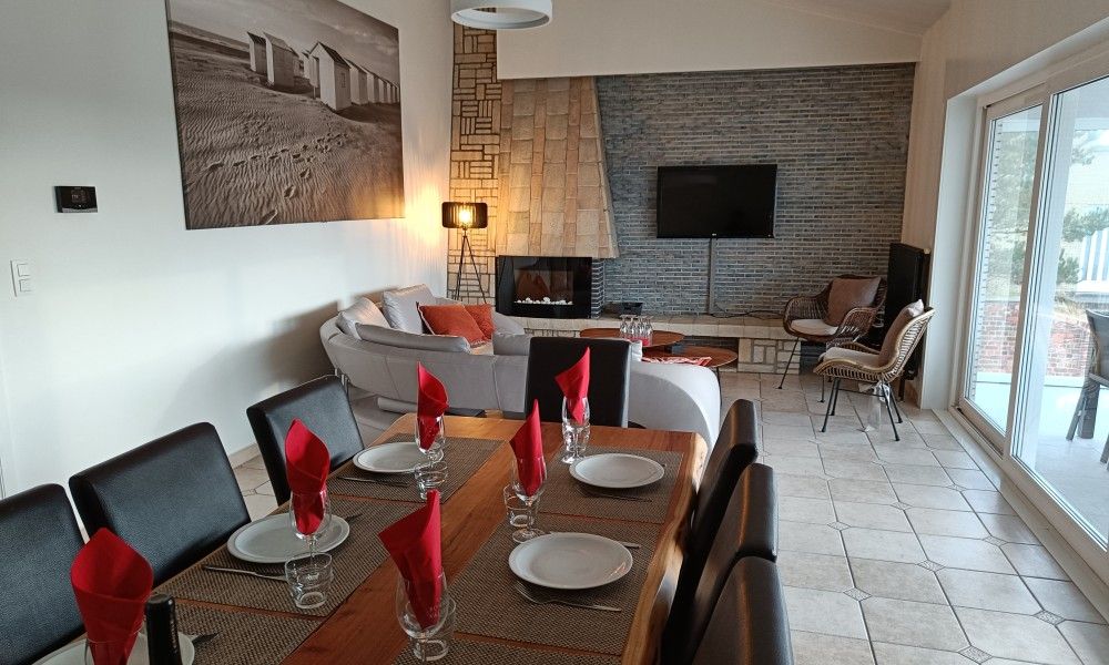 Stylish dining room in Papa's Dream vacation home, Oostduinkerke, with set table and modern furnishings.