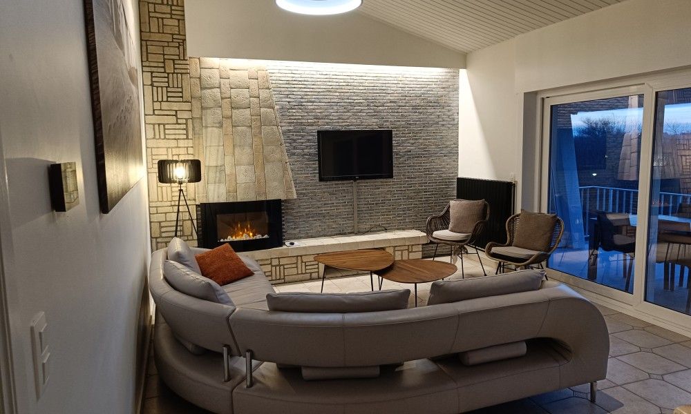 Cozy sitting area with fireplace in Papa's Dream vacation home, Oostduinkerke, ideal for relaxation.