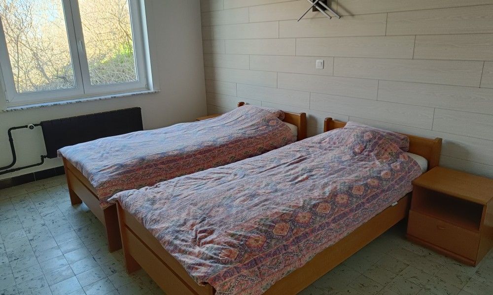 Papa's Dream vacation home in Oostduinkerke, spacious bedroom with wooden bed and lots of light.