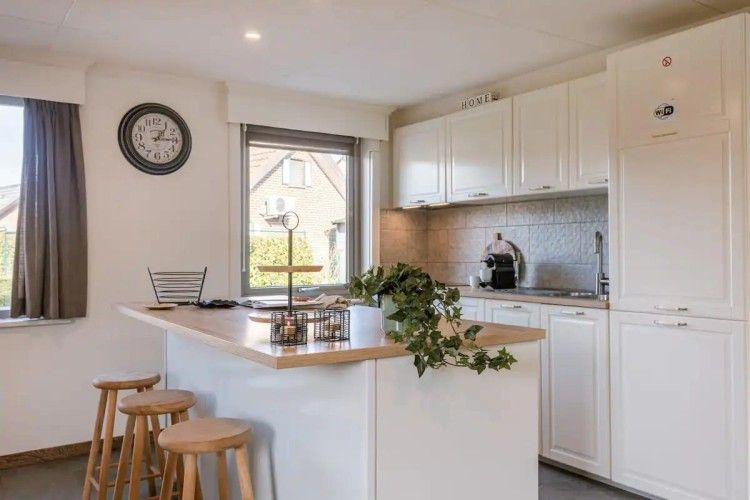 Modern kitchen in Maison du coeur, vacation home in Oostduinkerke, West Flanders, with bright decor and bar.