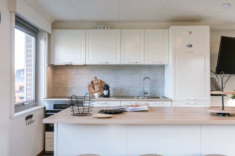 Stylish kitchen with island in Maison du coeur, vacation home in Oostduinkerke, West Flanders.