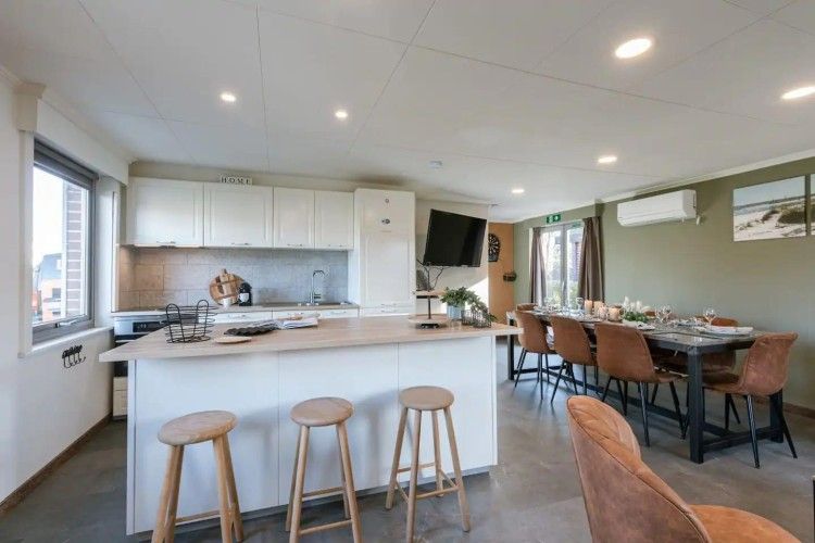 Spacious dining room and kitchen in Maison du coeur, vacation home in Oostduinkerke, West Flanders, with comfortable seating.