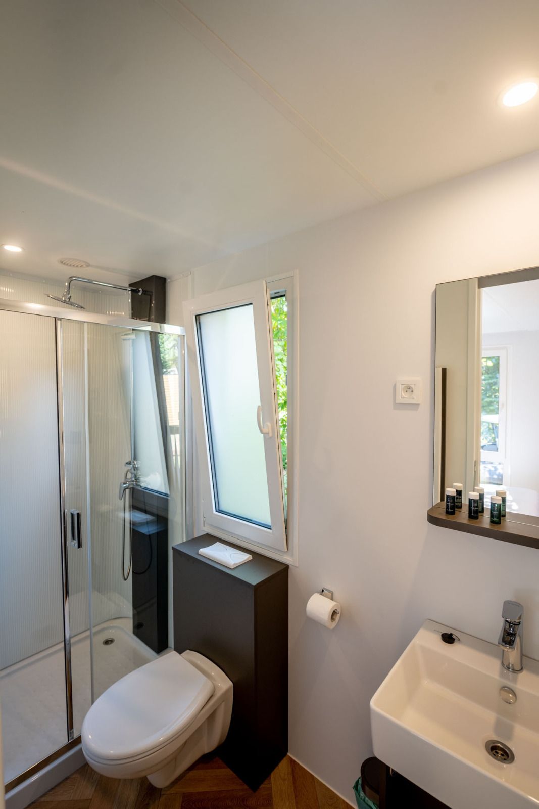 Modernes Badezimmer im Lodge-Ferienhaus in Gent, Ostflandern, mit geraeumiger Dusche und Blick ins Gruene.