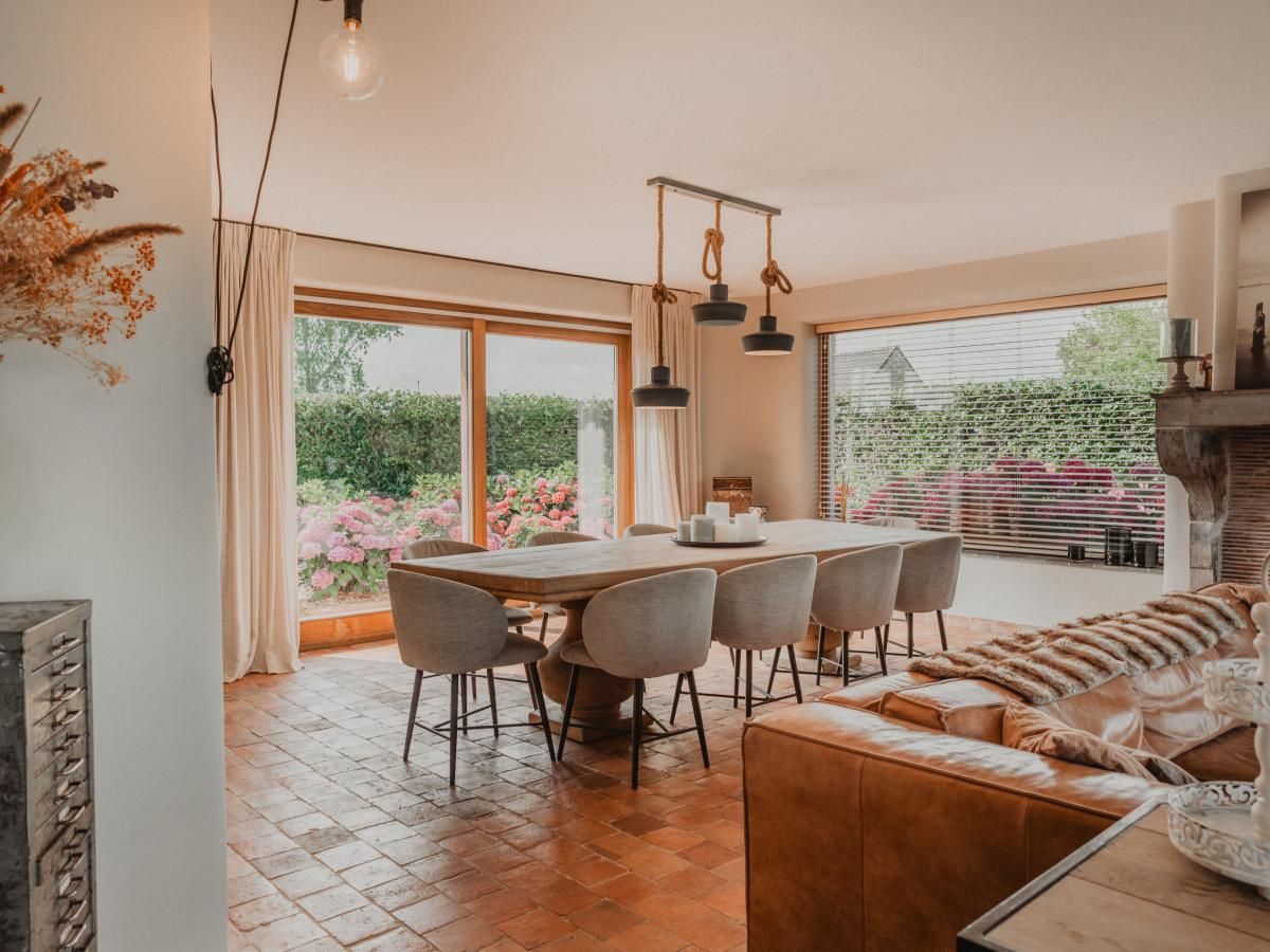 Stijlvolle eetkamer in Villa Noortem, een vakantiehuis in Maldegem, Oost-Vlaanderen, met uitzicht op de tuin en veel natuurlijk licht.