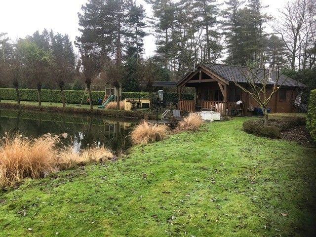 Rustikales Chalet Au Repeau an einem Teich in Moerzeke, Ostflandern, umgeben von viel Gruen.