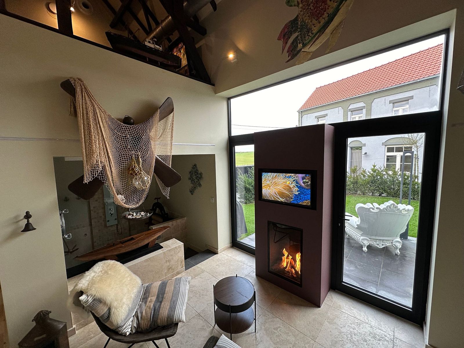 Cozy indoor area of Holiday Home Einzigartiger Wellness-Bauernhof in Wichelen, East Flanders with fireplace and garden view.