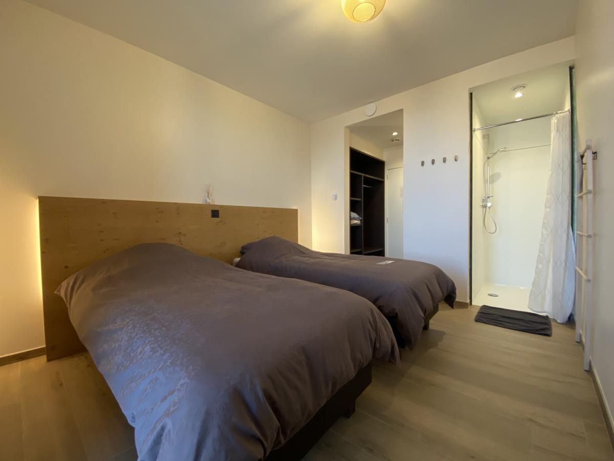 Komfortables Schlafzimmer in der Villa Mareon, Ferienhaus in Maarkedal, Ostflandern, mit zwei Betten und eigenem Bad.