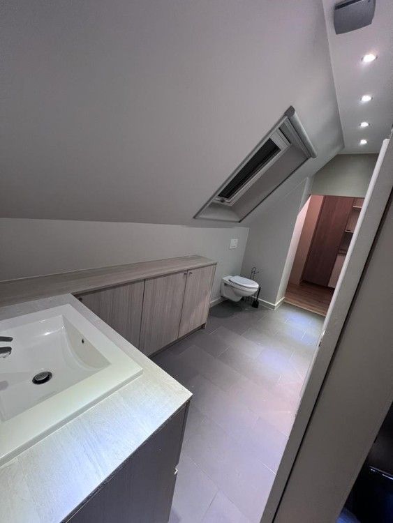 Moderne badkamer in appartement /, Bevere, Oost-Vlaanderen, Belgie, met strakke lijnen en dakraam voor natuurlijk licht.