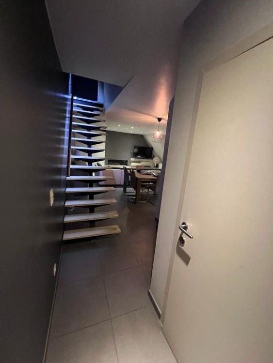 Moderne binnenruimte van appartement / in Bevere, Oost-Vlaanderen, met stijlvolle trap en gezellige woonkamer.