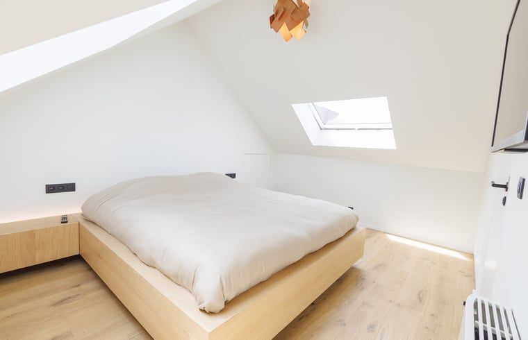 Gemuetliches Schlafzimmer im Ferienhaus in Sint-Pieters-Leeuw, Flaemisch-Brabant, Belgien, mit Holzboden und moderner Beleuchtung.