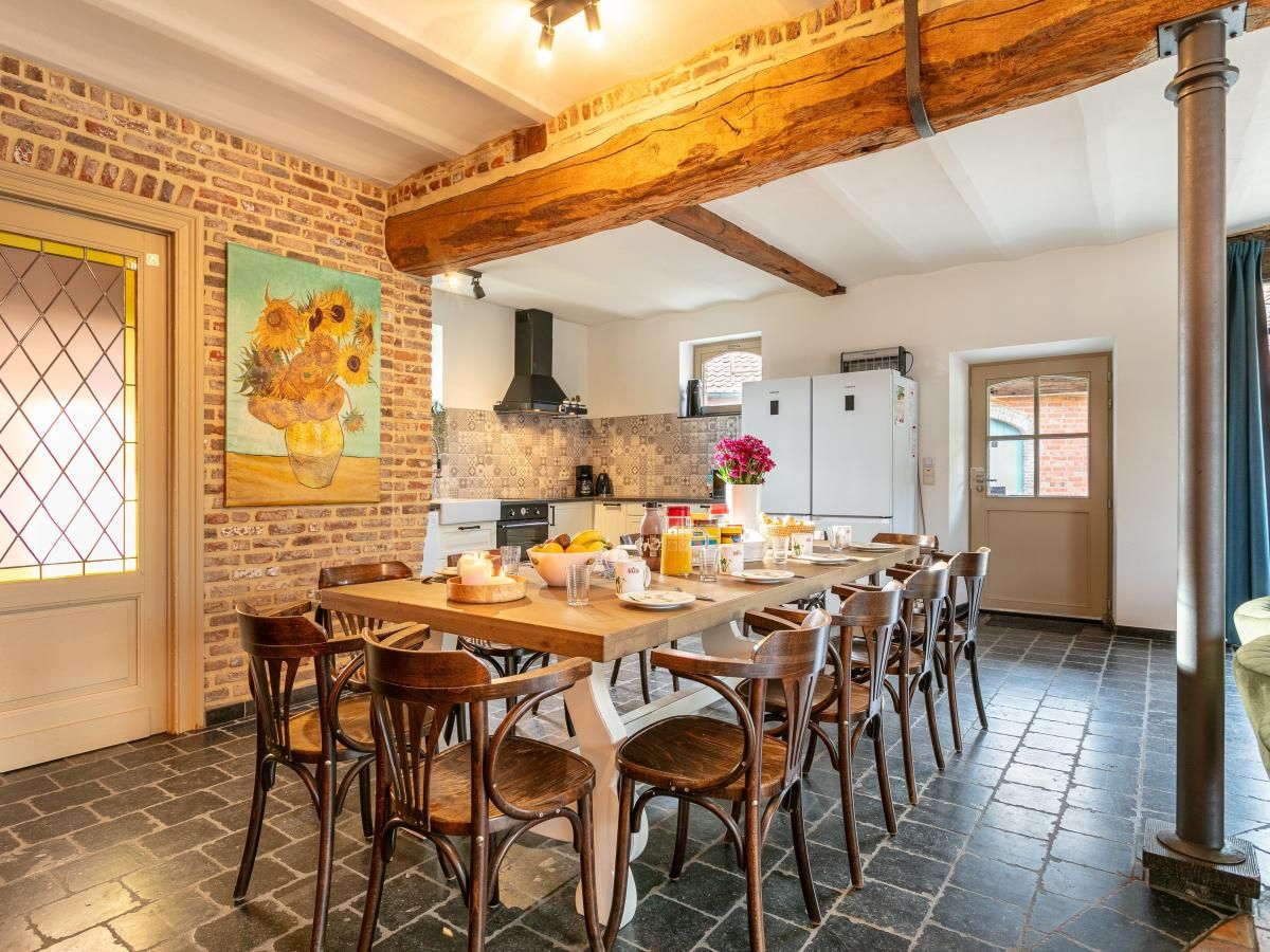 Gezellige eetruimte in vakantiehuis Alverwege, Merksplas, Antwerpen met rustieke houten balken en een ruime eettafel voor groepsdiners.