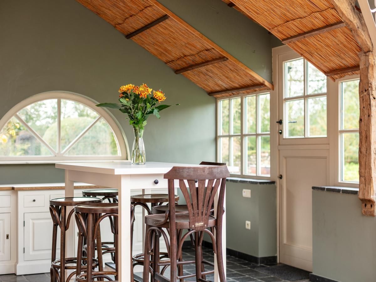 Gezellige eetruimte in vakantiehuis Alverwege, Merksplas, Antwerpen, Belgie, met houten interieur en uitzicht op de natuur.