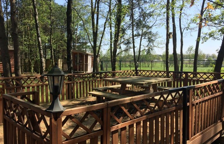 Veranda of Cottage in Merksplas, vacation accommodation in Antwerp surrounded by trees and nature.