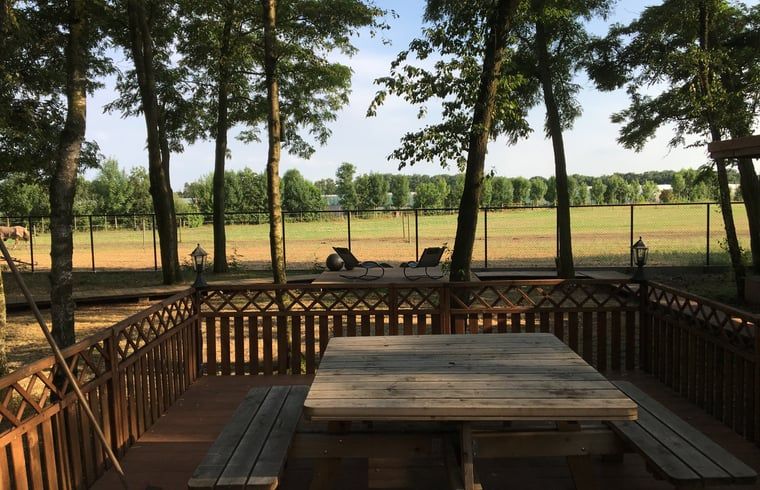Picnic table on terrace of Cottage in Merksplas, vacation accommodation in Antwerp overlooking meadows.