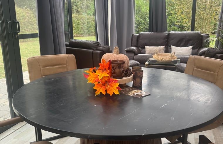 Cozy sitting area in Holiday Home in Merksplas, Antwerp, Belgium overlooking green garden, ideal for a relaxing stay.