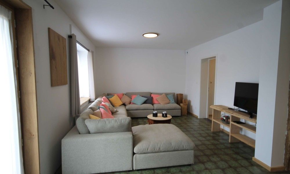 Gemuetliches Wohnzimmer im Huisje Nostalgie, Laakdal, Antwerpen, mit bequemen Sofas und bunten Kissen.