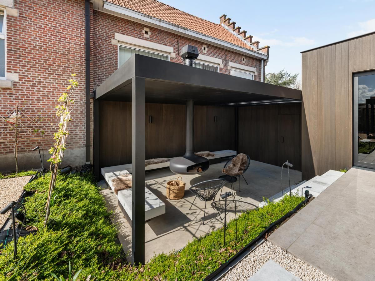 Gezellige veranda bij Pastorie Liezele, vakantiehuis in Puurs-Sint-Amands, Antwerpen, met moderne zitruimte en groene omgeving.