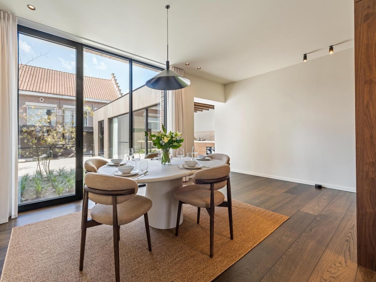 Stijlvolle eetkamer in vakantiehuis Pastorie Liezele, Puurs-Sint-Amands, Antwerpen, met veel lichtinval en moderne inrichting.