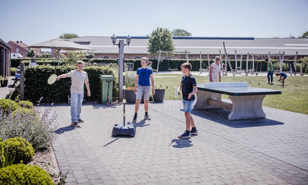 Children play table tennis at Driehoekshoeve vacation home, Kasterlee, Antwerp.