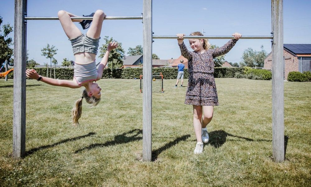 Children play outside at Driehoekshoeve vacation home, Kasterlee, Antwerp.