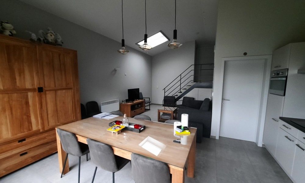 Modernes Interieur von De Drieshoeve, Ferienhaus in Kasterlee, Antwerpen, mit Esstisch aus Holz.