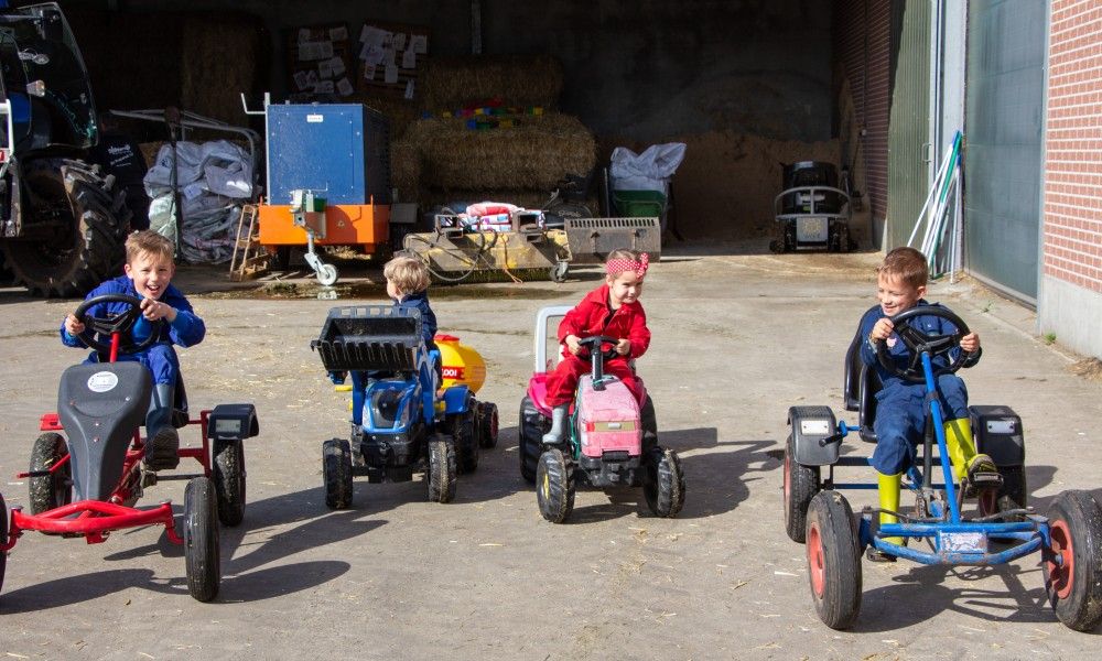 Kinder spielen auf Go-Karts in De Drieshoeve, einem Ferienhaus in Kasterlee, Antwerpen.