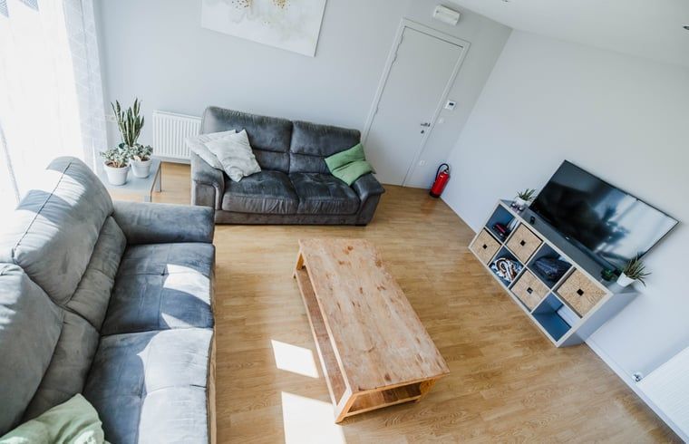 Gemuetliches Wohnzimmer im Cottage in Kasterlee, einem Ferienhaus in Kasterlee, Antwerpen, Belgien, mit bequemen Sofas und modernen Moebeln.