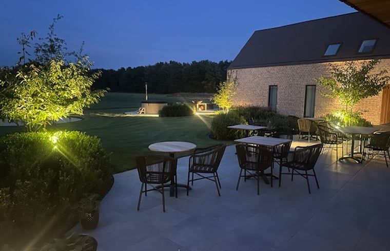 Cozy illuminated terrace at Holiday Home in Kasterlee, Antwerp, Belgium, surrounded by peaceful nature and beautiful evening scenery.