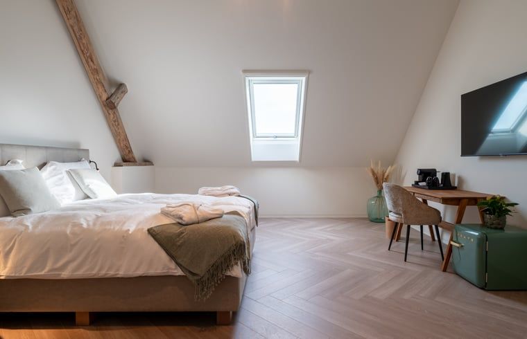 Bright bedroom in Holiday Home in Kasterlee, Antwerp, Belgium with comfortable bed and rustic beams.